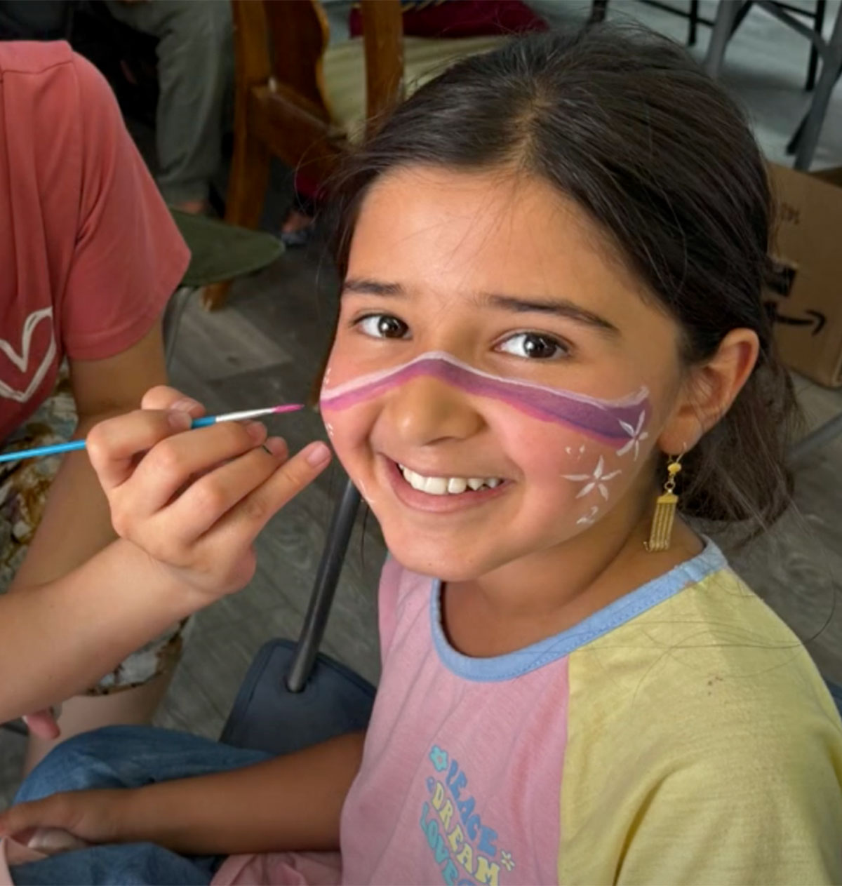 Young girl smiling while getting face painted